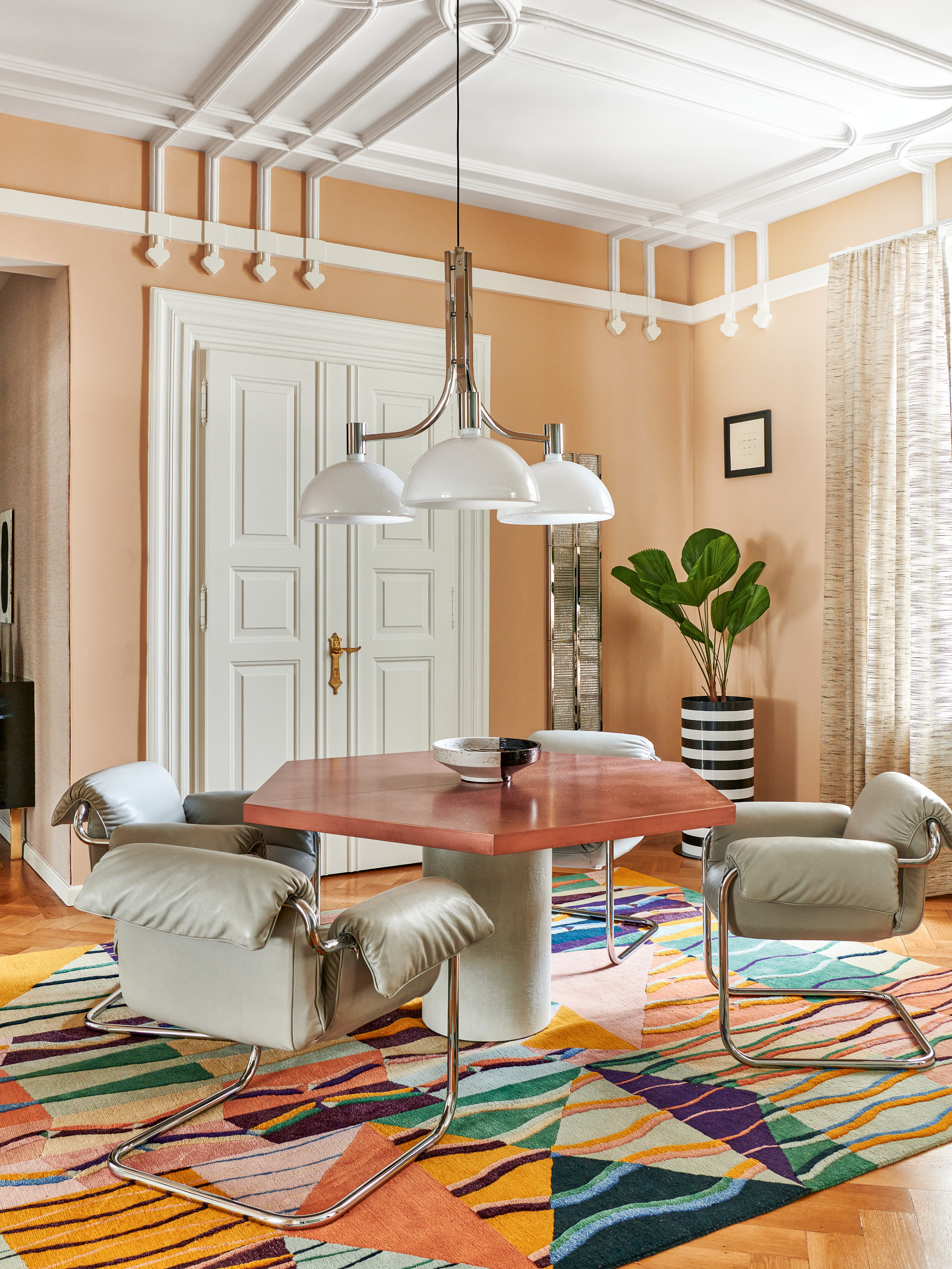Dining room with hexagonal table, leather chairs and multicolour rug