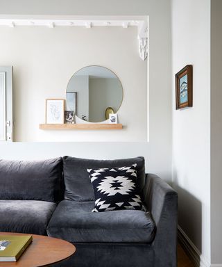 small white living room with dark velWhile this might seem a dramatic move, you can increase the sense of space by opening up the wall behind the sofa, revealing the light-filled hallway behind it.