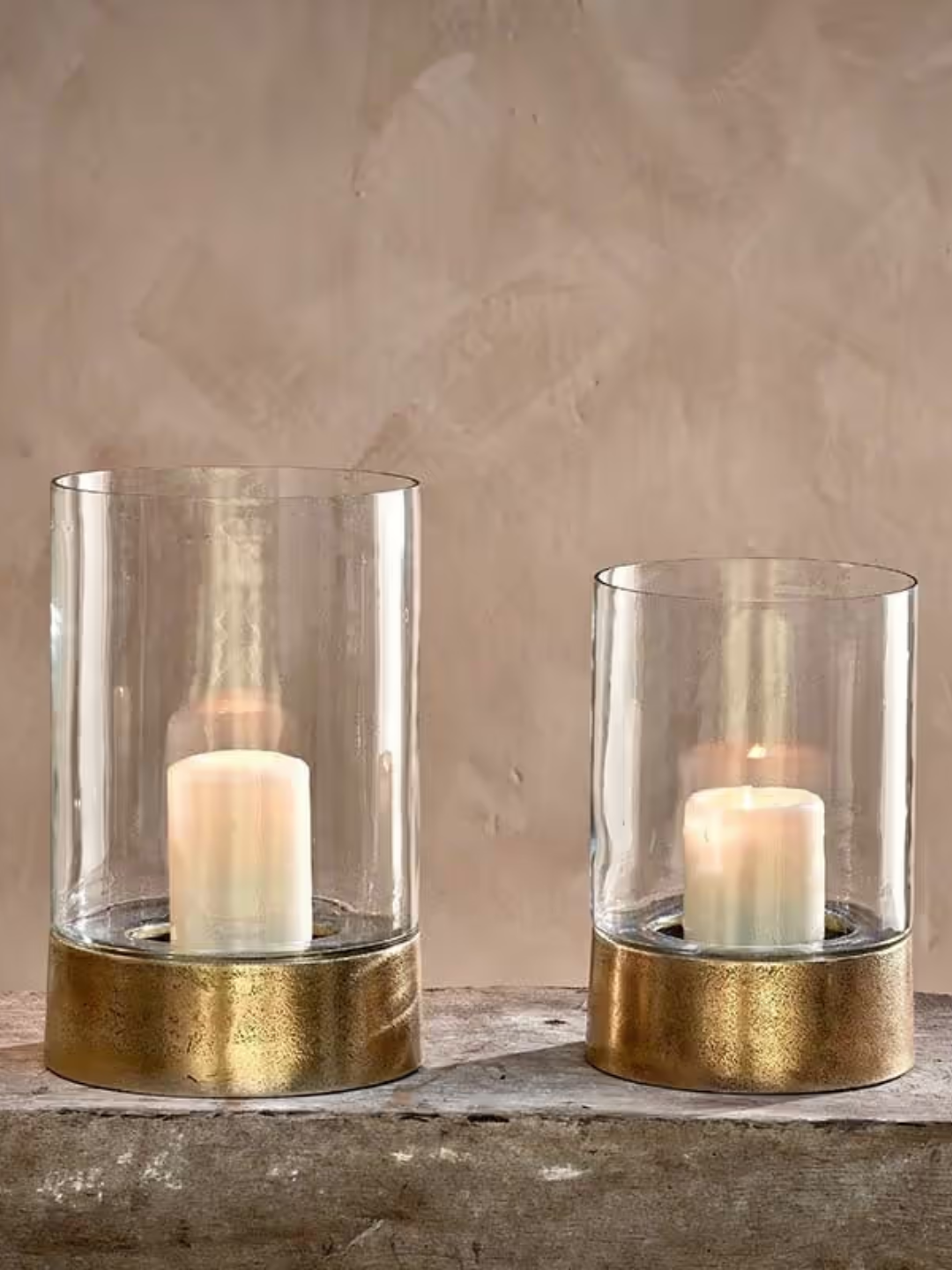 A glass lantern with a patinaed gold base from nkuku