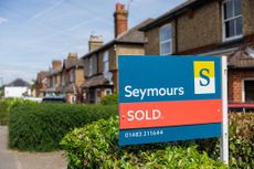 An estate agent sold sign outside a residential property in Woking, UK