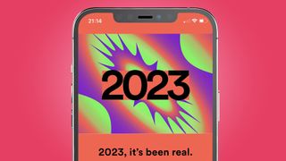 An iPhone on a pink background showing a splash page for Spotify Wrapped 2023