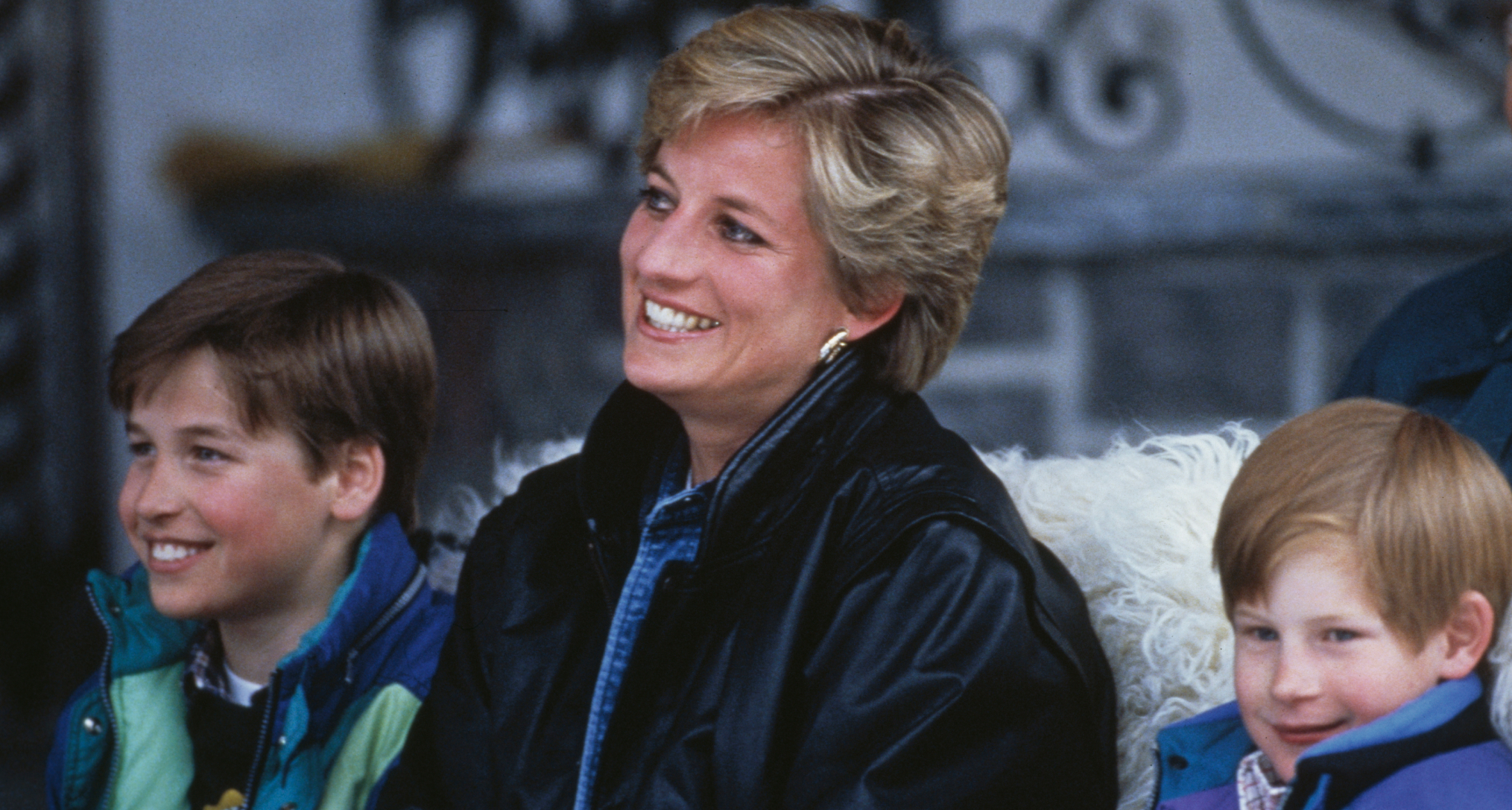 Princess Diana sitting in a sleigh with Harry and William