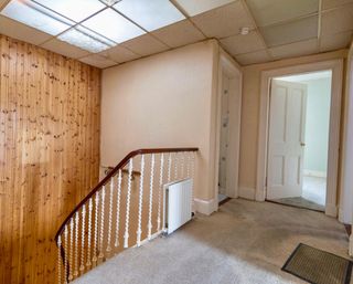 'Before' shot showing landing with pine panelling and beige walls