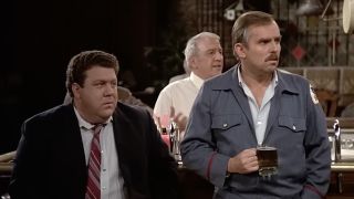 Norm and Cliff watching a scene unfold near the bar in Cheers