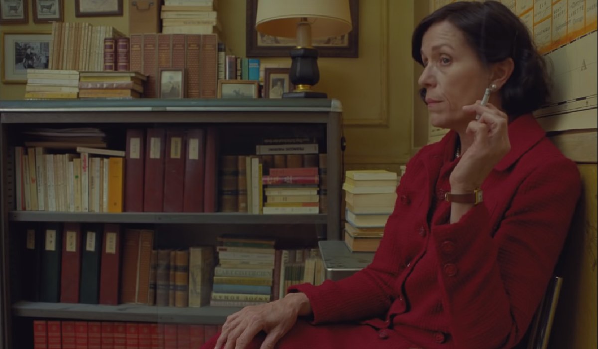 The French Dispatch Frances McDormand smoking and listening in an office