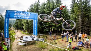 MTB rider whipping his bike at the iconic Scotland jump at Fort William