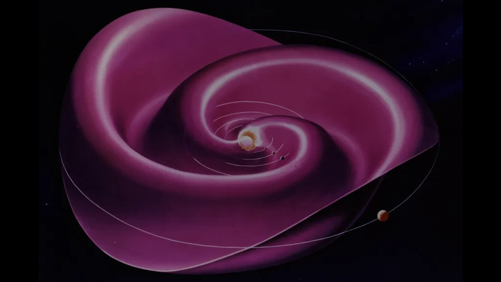 El Sol está en el centro y una capa violeta giratoria se extiende hacia el interior del sistema solar.  Se parece un poco a la falda de una bailarina, ondulada y desordenada mientras giran.