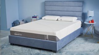 The image shows the Tempur-Pedic Tempur-Cloud mattress on a blue bed foundation in a blue bedroom