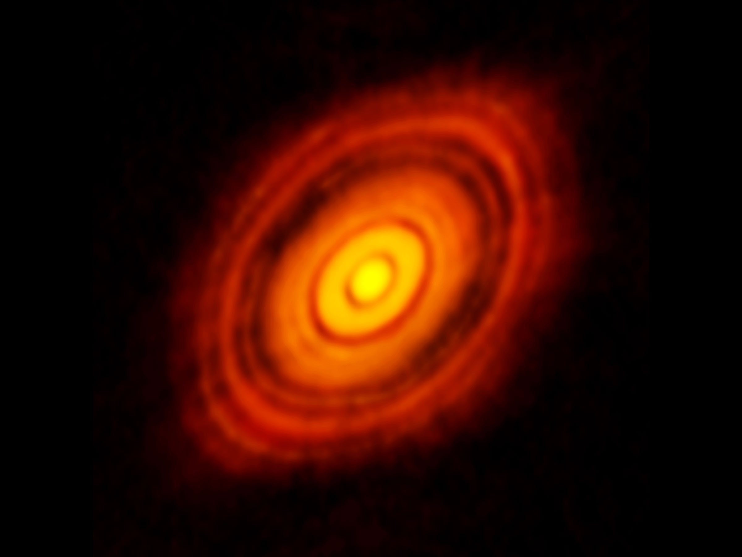 photo of fuzzy yellow and orange concentric rings in deep space