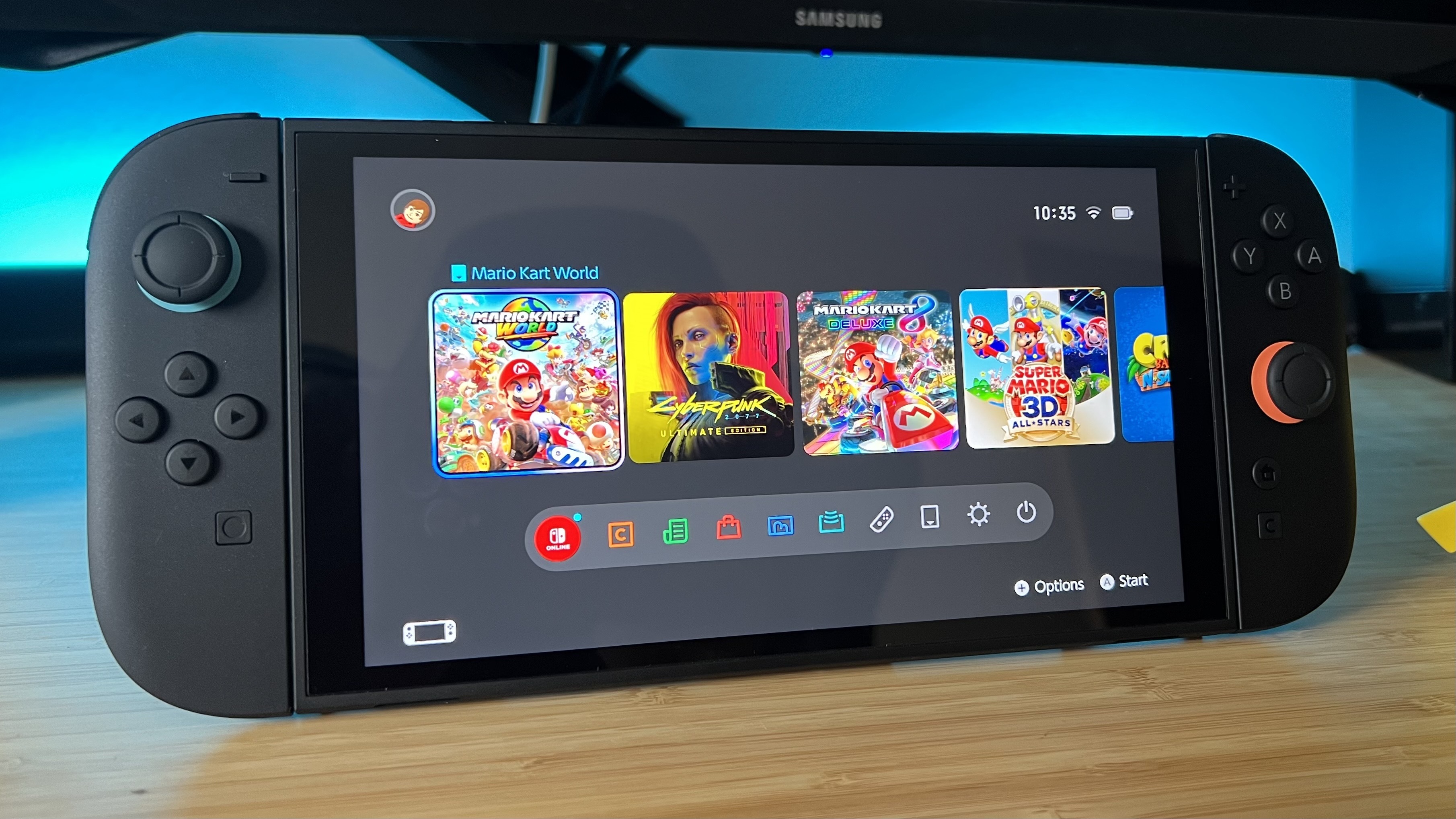 Nintendo Switch 2 homescreen showing on the console on a wooden desk
