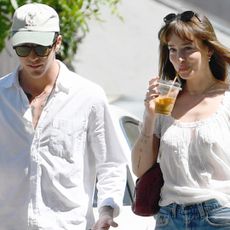 Dakota Johnson went out with rumored boyfriend Role Model dressed in a boho shirt trend, jeans, ballet flats, and a burgundy The Row bag