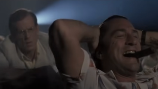 Robert De Niro smokes a cigarette and laughs really loudly while watching a movie in Cape Fear.