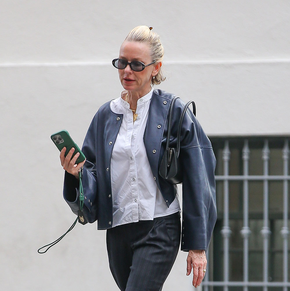 Naomi Watts wearing a white button-down, black leather jacket, black jeans, and white jazz shoes