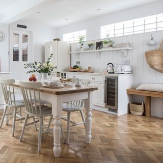 French country kitchen with white walls and cabinets and farmhouse table
