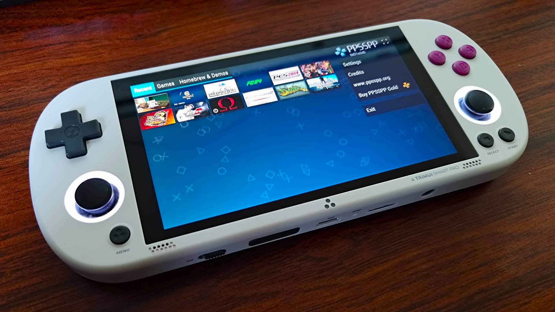 Trimui Smart Pro handheld on desk with PPSSPP open.