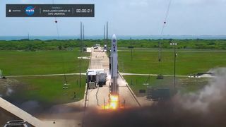 rocket lifts off with green grass in the background