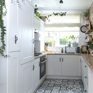 white shaker kitchen with patchwork floor tiles