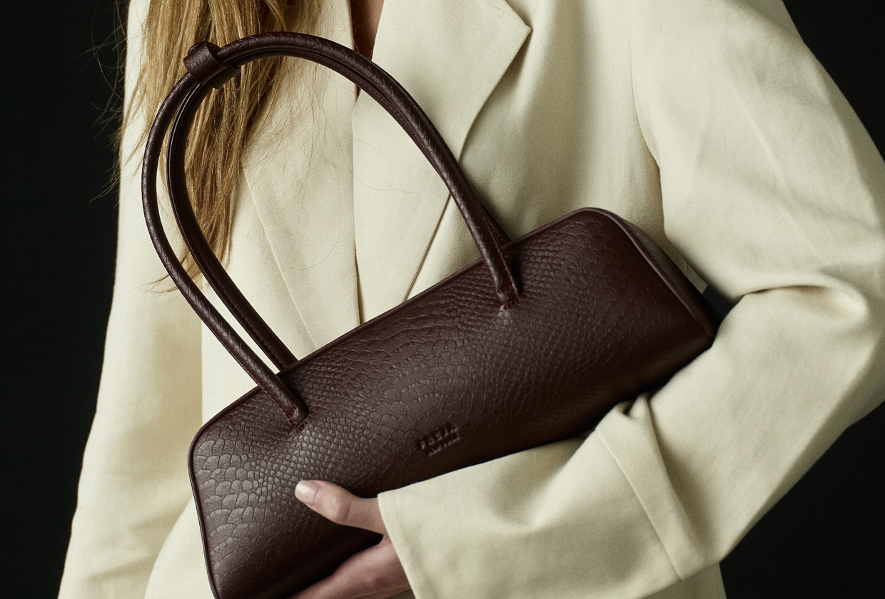 Woman wearing brown Freja vegan leather bag.