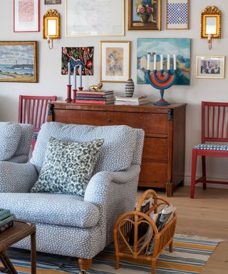 living room with summer gallery wall and blue upholstered armchairs