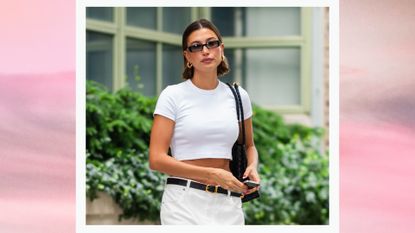 Hailey Bieber is pictured wearing a white crop top, black sunglasses and gold earrings in Tribeca on June 16, 2023 in New York City./ in a pink and grey gradient template