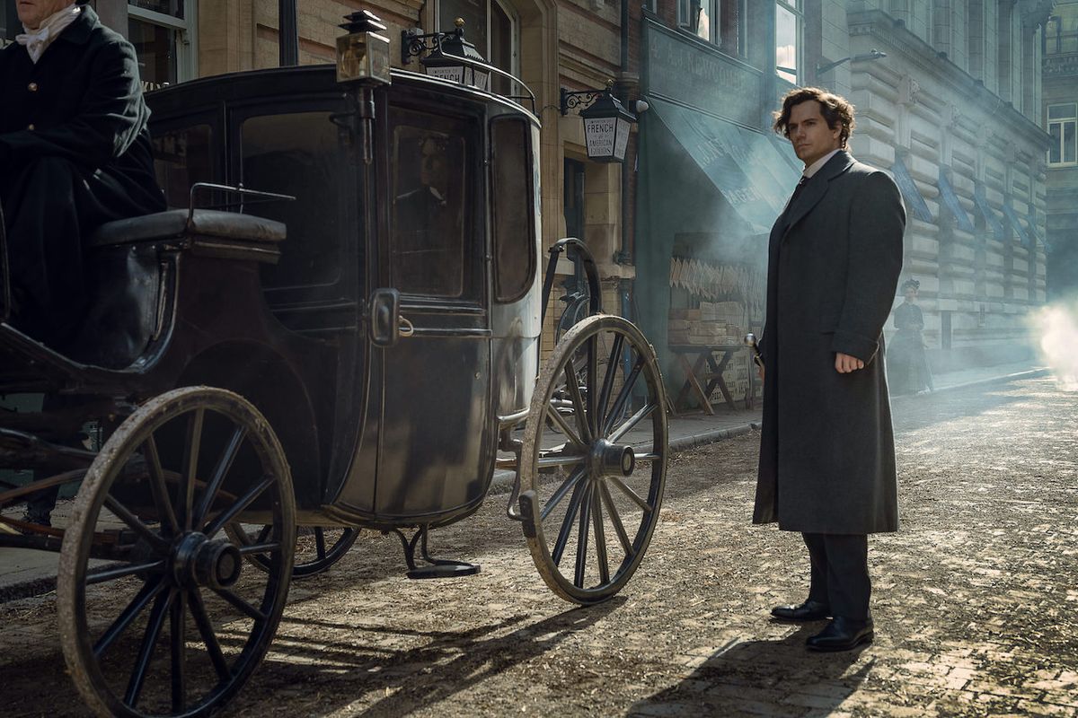 Henry Cavill's Sherlock Holmes standing next to carriage in evening in Enola Holmes 2