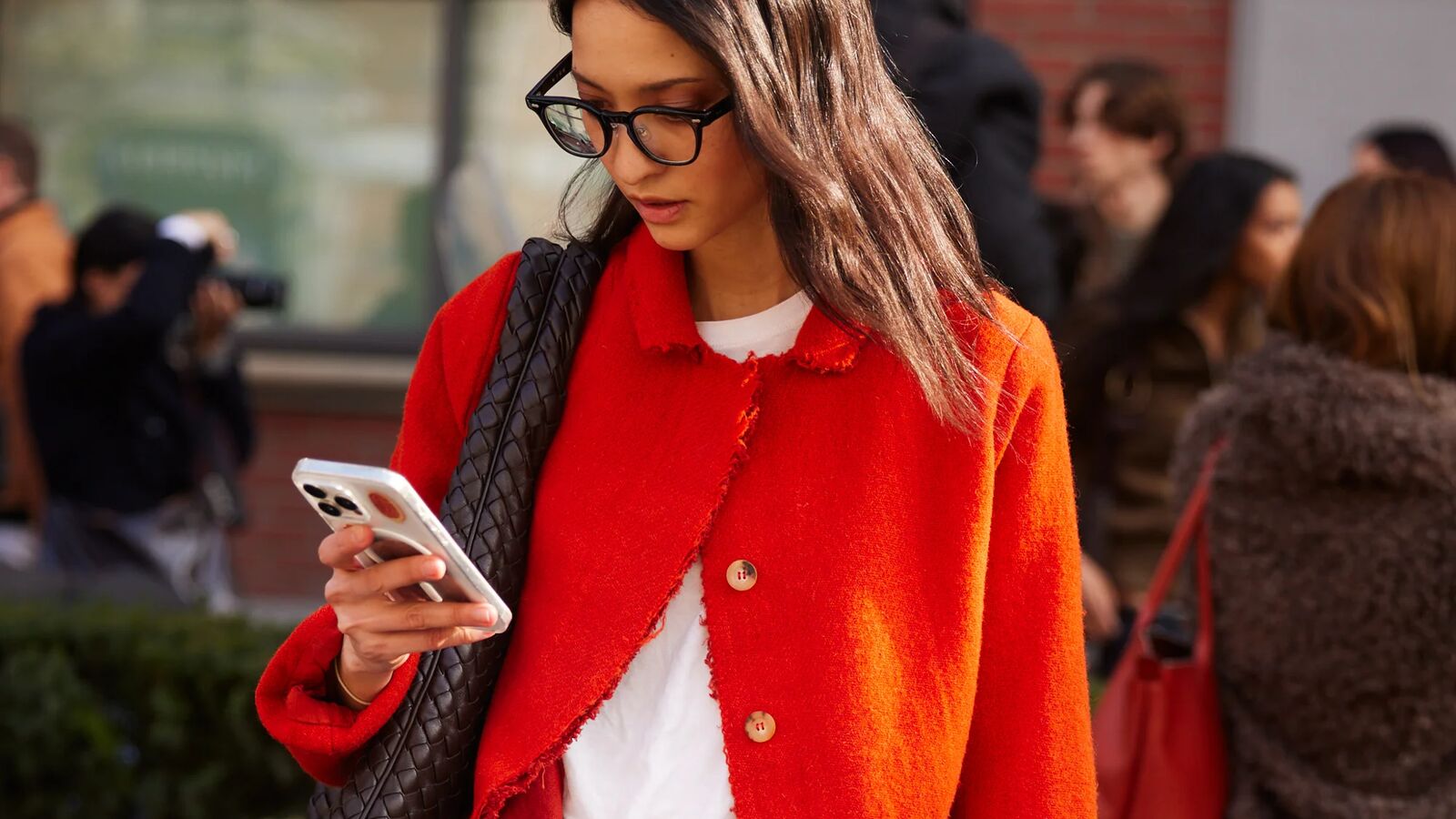 Woman in red sweater looking at her phone