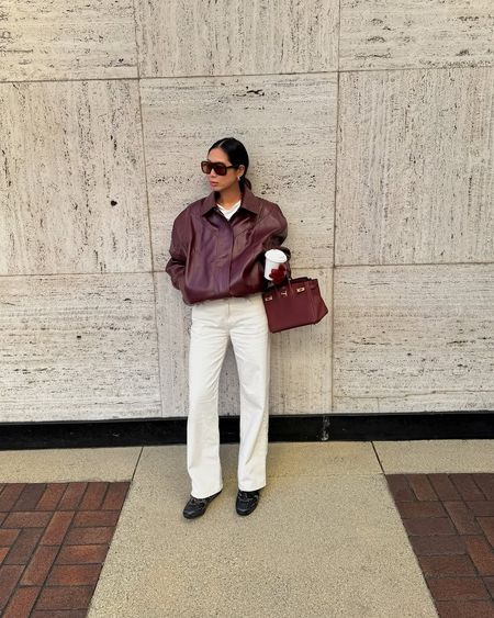 woman wearing leather jacket and white jeans