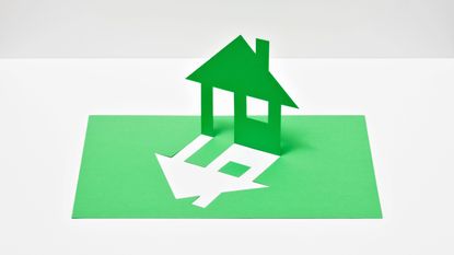 A house silhouette cut out from a sheet of green paper
