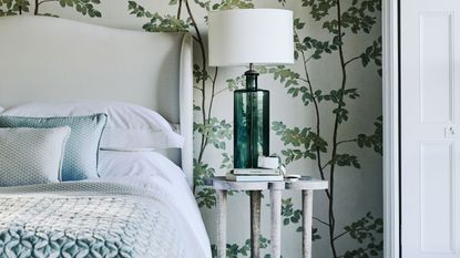 bedroom with green natural themed wallpaper and glass table lamp