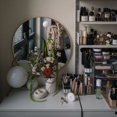 Photo of Erica Choi taking a mirror selfie at her makeup vanity