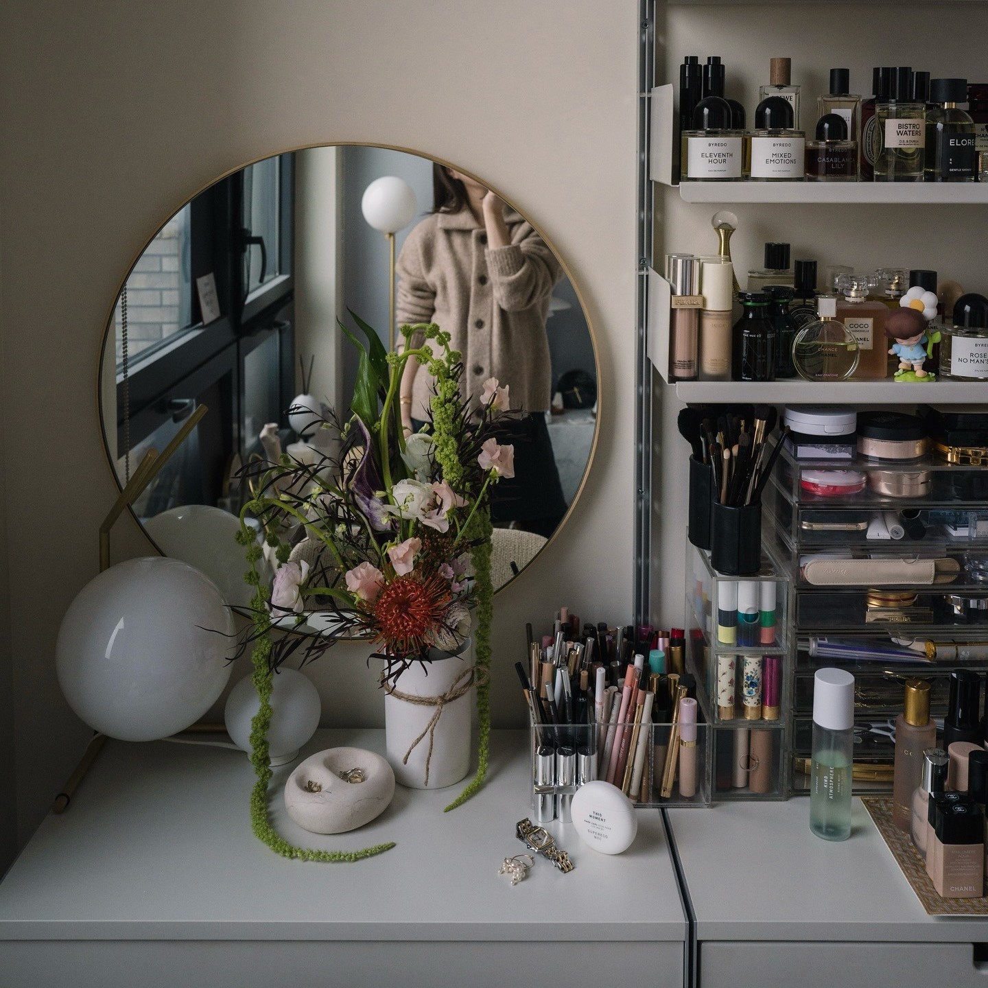 Photo of Erica Choi taking a mirror selfie at her makeup vanity