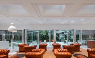 Large aluminium framed windows pivot out opening the ground floor up to the gardens and urban centre of The Hague