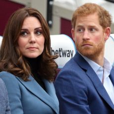 Kate Middleton wears a turquoise jacket and has bouncy dark brown hair and Prince Harry has red hair and beard