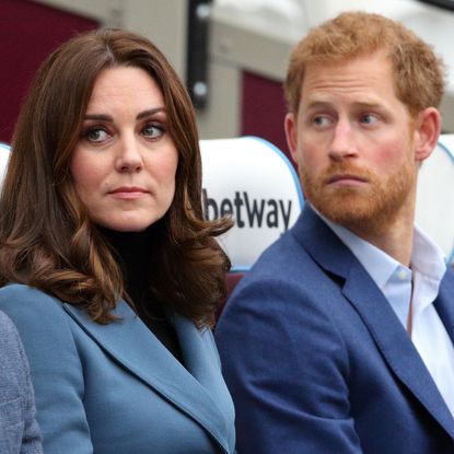 Kate Middleton wears a turquoise jacket and has bouncy dark brown hair and Prince Harry has red hair and beard