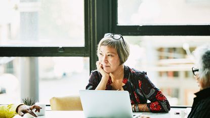 A businesswoman listens intently to an employee talking.