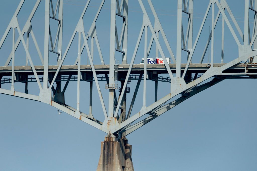 FedEx truck travels across bridge.