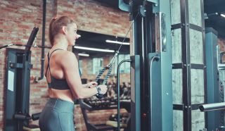 Woman uses cable machine in gym