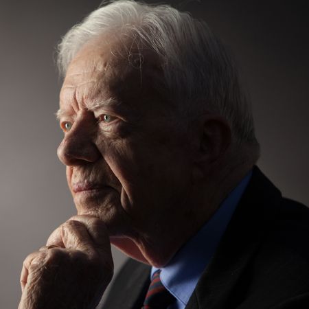 King Charles wears military uniform and stares into the distance and Jimmy Carter looks pensive