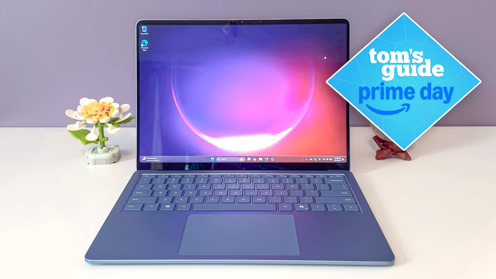 Microsoft Surface Laptop 7 on table next to lego flower with Tom's Guide Prime Day badge