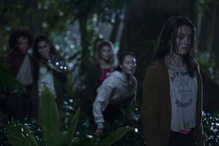 Mia Healey (Shelby Goodkind), Erana James (Toni Shalifoe), Sarah Pidgeon (Leah Rilke) in the woods at night in The Wilds season 2
