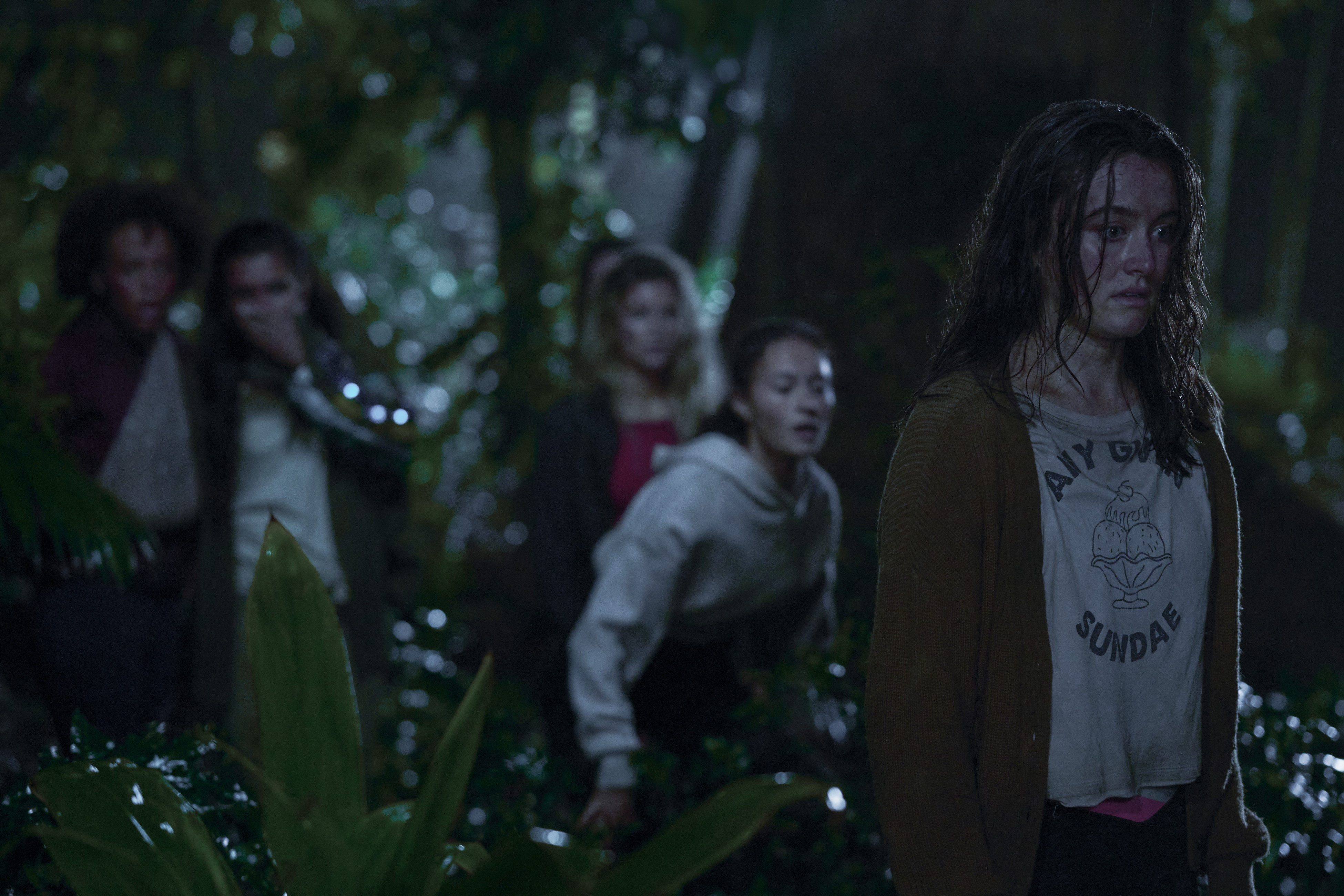 Mia Healy (Shelby Goodkind), Erana James (Tony Shalifo), Sarah Pidgeon (Leah Rilke) in the woods at night in The Wilds Season 2
