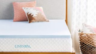 Image shows the Linenspa 3 Inch Gel Infused Memory Foam Mattress Topper on a wooden bed frame in a sunny bedroom