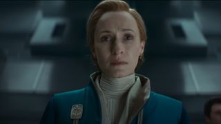 A worried woman in a blue-and-white sci-fi uniform