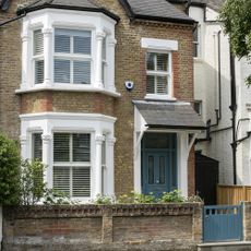 brick semi detached house with blue gate and blue front door