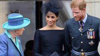 Queen Elizabeth II, Meghan, Duchess of Sussex, Prince Harry, Duke of Sussex watch the RAF flypast on the balcony of Buckingham Palace, as members of the Royal Family attend events to mark the centenary of the RAF on July 10, 2018 in London, England.