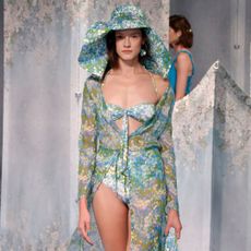 Model wears bikini with matching hat and robe on the runway