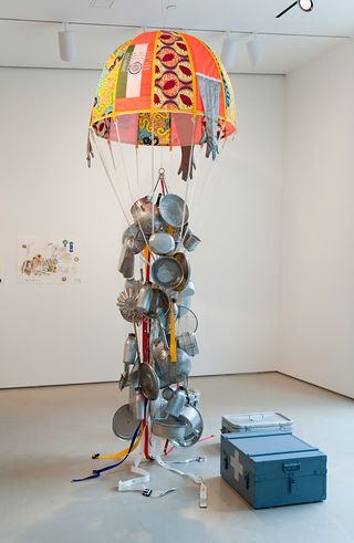 A multi-coloured mini parachute with pots and pans hanging from the ropes below.