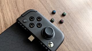 GameSir X2 Pro with the face buttons removed and lying next to it