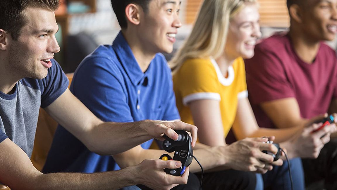 The best retro controllers; a photo of four people playing on a Switch