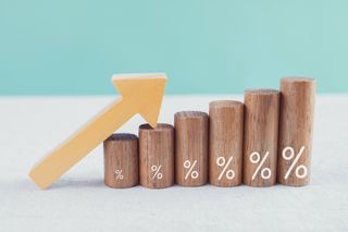 Wooden blocks with percentage sign and arrow up, financial growth, interest rate and mortgage rate increase, inflation concept